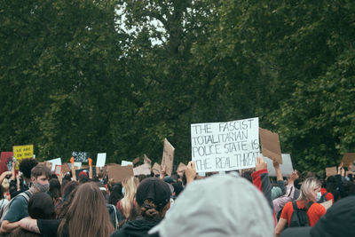 Rear view of people on street against trees