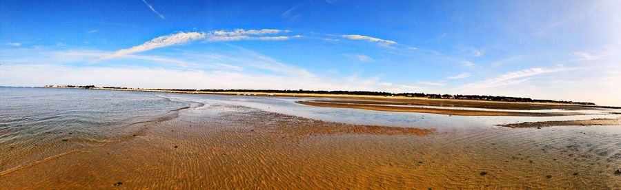 Scenic view of beach against blue sky