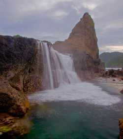 Scenic view of waterfall against sky