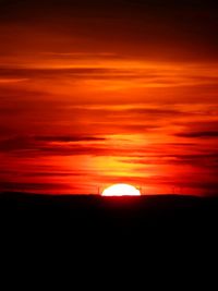 Scenic view of silhouette landscape against orange sky