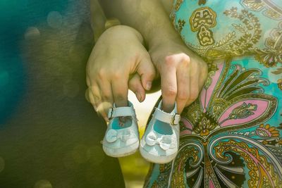 Midsection of couple holding baby booties