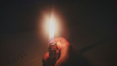 Close-up of hand holding lit candle