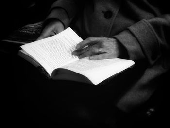 Midsection of man holding book