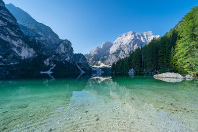 Bright color of water of lake braies and its reflections, italian landscape in south tyrol