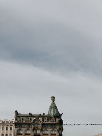 Low angle view of building against cloudy sky