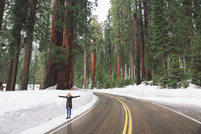 View of woman walking on snow covered road