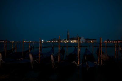 View of boats moored in city at night