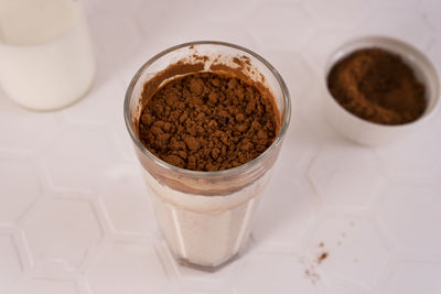 Delicious homemade cocoa drink with milk, cocoa powder and pieces of chocolate bar.