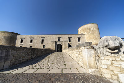 Old ruins of building against clear blue sky