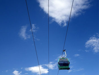 Low angle view of overhead cable car against blue sky