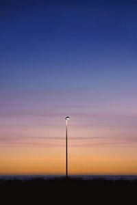 Street light against orange sky