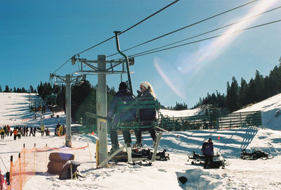 People enjoying at angel fire resort against sky during sunny day