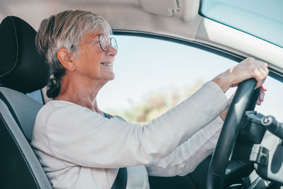 Side view of man using mobile phone while sitting in car