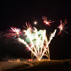 Low angle view of firework display at night