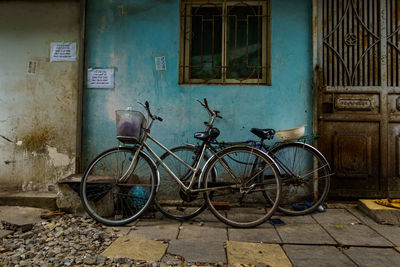 Bicycle parked against abandoned building