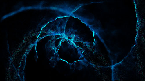 Close-up of blue light painting against black background