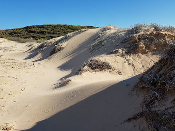 Scenic view of desert against clear blue sky