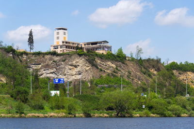 Building by lake against sky