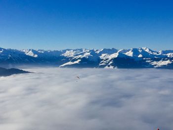 Scenic view of snowcapped mountains against blue sky