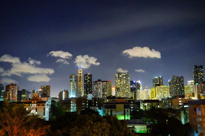 Illuminated buildings in city against sky