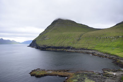 Scenic view of sea and mountains against sky