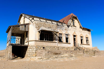 Low angle view of old building against clear blue sky