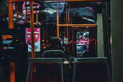 Rear view of people sitting on chair in city