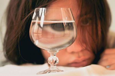 Close-up portrait of woman in wineglass