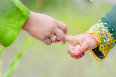 Cropped image of wedding couple holding hands