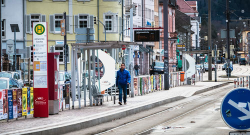 People walking on street amidst buildings in city