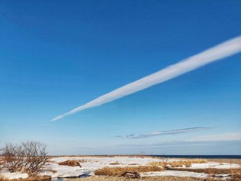 Scenic view of snow covered land against blue sky