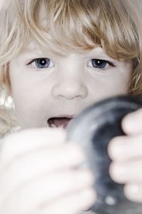 Close-up of baby girl holding camera