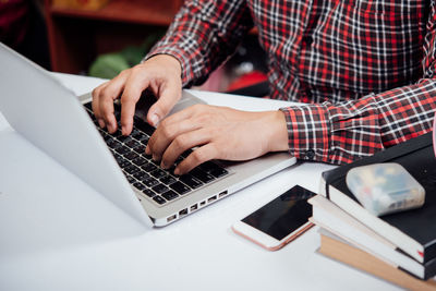 Midsection of man using laptop on table