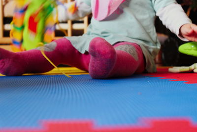 Low section of baby sitting on carpet