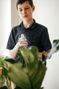 Portrait of young woman holding plant