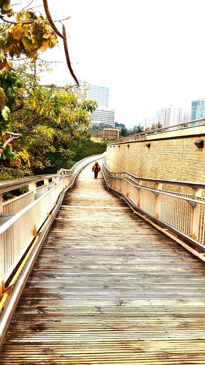 FOOTBRIDGE OVER CITY AGAINST SKY