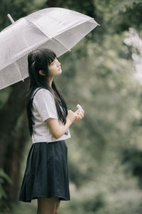 Woman wearing hat standing against blurred background