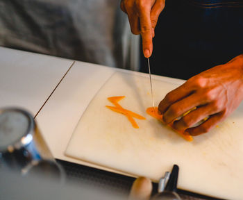 Midsection of chef cutting food on cutting board