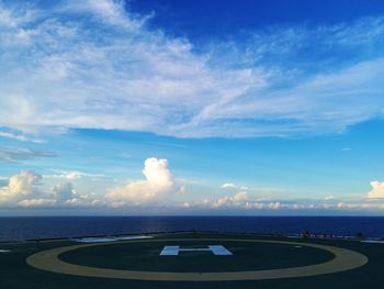 Road by sea against blue sky