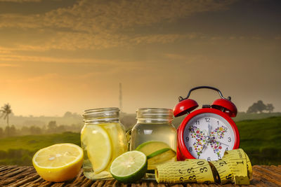 Fruits in glass jar on table against sky during sunset