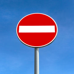 Close-up of road sign against clear blue sky