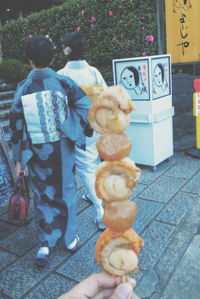 Rear view of man and woman standing on sidewalk