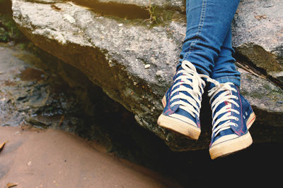 Low section of person relaxing on rock