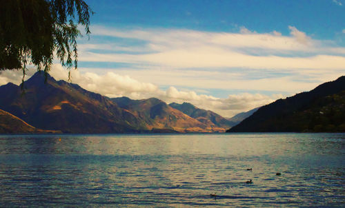 Scenic view of sea and mountains against sky