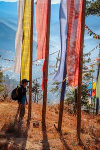 Rear view of man standing on field against sky