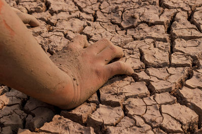 Close-up of dirty hands on drought land