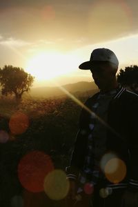 Silhouette of people on field at sunset