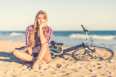 Young woman on beach against sky