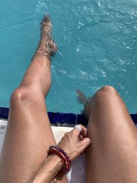 Low section of woman relaxing in swimming pool
