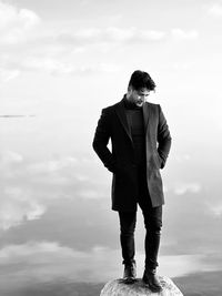 Young man standing against sea